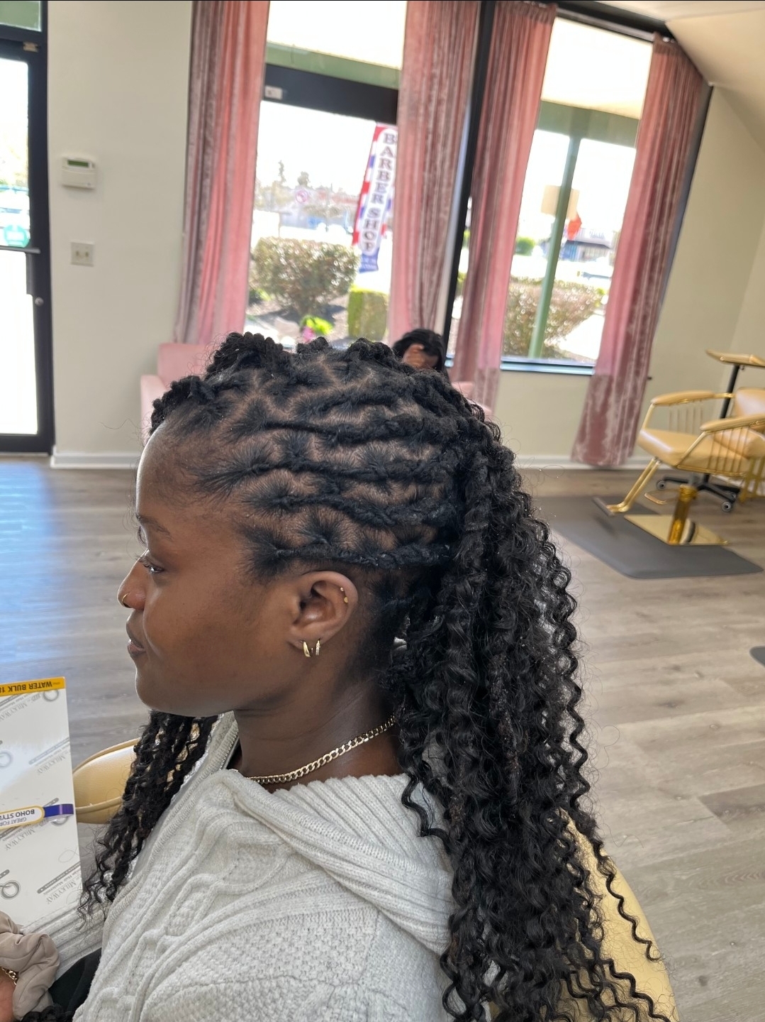 Young woman with loc-and-curly extension ponytail in cream sweater — loc styles Sinkor Beauty Salon