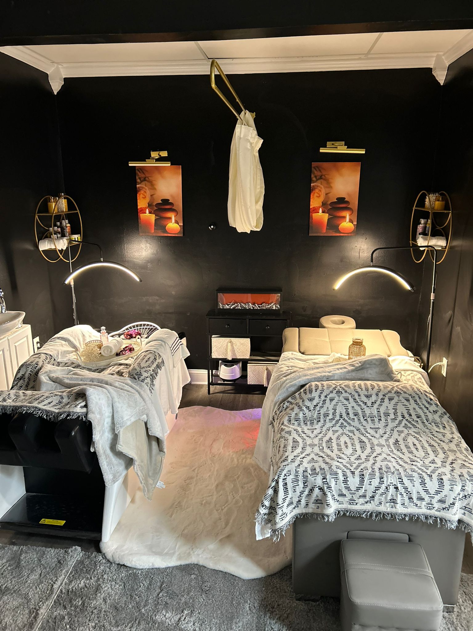 Spa treatment room at Sinkor Beauty Salon — dark walls, ambient candle art, dual treatment beds, zen atmosphere